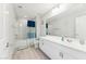 Bright bathroom featuring a bathtub with shower, modern vanity, and a large mirror at 8754 W San Juan Ave, Glendale, AZ 85305