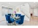 Formal dining room with modern glass top table and bright blue chairs at 8754 W San Juan Ave, Glendale, AZ 85305
