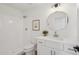 A modern bathroom features a shower and vanity with a round mirror at 9263 W Oraibi Dr, Peoria, AZ 85382