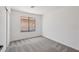 A clean, neutral bedroom features plush carpeting and a window letting in natural light at 9263 W Oraibi Dr, Peoria, AZ 85382