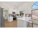 Bright kitchen with white cabinetry, quartz countertops, stainless appliances, and breakfast bar at 9263 W Oraibi Dr, Peoria, AZ 85382
