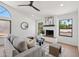 Cozy living room with a modern ceiling fan, fireplace, and neutral decor at 9263 W Oraibi Dr, Peoria, AZ 85382