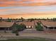 Back of home shows desert landscaping and covered patio at sunset at 9263 W Oraibi Dr, Peoria, AZ 85382