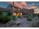 Inviting patio and lush desert landscaping surround this charming two-story home at dusk at 9270 E Thompson Peak Pkwy # 347, Scottsdale, AZ 85255