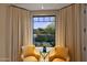 Cozy sitting area with comfortable chairs, a view of the outdoor patio, and stylish window treatments at 9270 E Thompson Peak Pkwy # 347, Scottsdale, AZ 85255