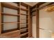 Spacious walk-in closet with custom wood shelving and hanging rods at 9270 E Thompson Peak Pkwy # 347, Scottsdale, AZ 85255