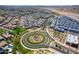 Aerial view features palm-lined streets, a central roundabout, and meticulously planned neighborhoods in a harmonious community layout at 9624 E Thunderbolt Ave, Mesa, AZ 85212