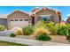 Inviting home featuring a two-car garage and beautifully landscaped front yard with colorful flowers at 9624 E Thunderbolt Ave, Mesa, AZ 85212