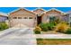 Charming home with a two-car garage and beautifully landscaped front yard with mature shrubs at 9624 E Thunderbolt Ave, Mesa, AZ 85212