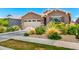 Charming home featuring a two-car garage and landscaped front yard with flowering plants and shrubs at 9624 E Thunderbolt Ave, Mesa, AZ 85212