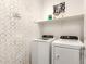 Functional laundry room features a washer, dryer, ample shelving, and playful decorative elements at 9624 E Thunderbolt Ave, Mesa, AZ 85212
