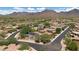 Wide aerial view of a desert community with mountain views and lush green landscaping at 9904 E South Bend Dr, Scottsdale, AZ 85255