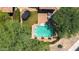 Drone shot overlooking the backyard with a pristine pool, trampoline, and paved patio seating area at 9904 E South Bend Dr, Scottsdale, AZ 85255