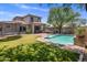 Expansive backyard features a sparkling pool, manicured lawn with a trampoline, and a shaded outdoor patio at 9904 E South Bend Dr, Scottsdale, AZ 85255