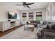 Inviting living room with a large sectional sofa, entertainment center, ceiling fan and plenty of natural light at 9904 E South Bend Dr, Scottsdale, AZ 85255