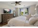 Well-lit primary bedroom featuring a plush bed, wooden dresser, and a serene view of the backyard pool at 9904 E South Bend Dr, Scottsdale, AZ 85255