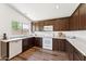 Bright kitchen with white countertops, dark wood cabinets, and stainless-steel appliances at 1029 E Jasper Dr, Gilbert, AZ 85296