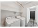 Functional laundry room with modern washer and dryer units, complemented by upper shelving for organized storage at 1029 E Jasper Dr, Gilbert, AZ 85296