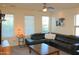 Living room with natural light, ceiling fan, and plush black leather sofa at 1100 S 176Th Ave, Goodyear, AZ 85338