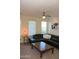 Living room with natural light, fan, and plush black leather sofa at 1100 S 176Th Ave, Goodyear, AZ 85338