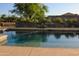 Sparkling pool with water feature surrounded by lush landscaping and a well-maintained patio at 1100 S 176Th Ave, Goodyear, AZ 85338