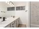 Bathroom featuring double sinks, matte black fixtures, and a marble style tub surround at 1202 E Libby St, Phoenix, AZ 85022