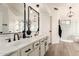 Bright bathroom featuring double sinks, matte black fixtures, and a glass enclosed shower at 1202 E Libby St, Phoenix, AZ 85022