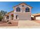 Two-story home featuring a terra cotta-colored roof, white stucco, arched windows, and a two-car garage at 1202 E Libby St, Phoenix, AZ 85022
