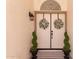 Charming double front door with decorative wreaths, sidelight windows, and potted spiral topiaries at 1202 E Libby St, Phoenix, AZ 85022