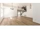 Bright living room featuring wood-look floors, modern light fixture, and staircase at 1202 E Libby St, Phoenix, AZ 85022