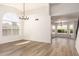 Bright living room featuring wood-look floors, modern light fixture, and large window at 1202 E Libby St, Phoenix, AZ 85022