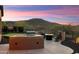 Sunset view of outdoor kitchen, fire pit, and putting green at 13072 W Alyssa Ln, Peoria, AZ 85383