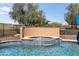Backyard tiled hot tub with a stone waterfall feature surrounded by desert landscaping at 13072 W Alyssa Ln, Peoria, AZ 85383