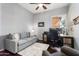 Office area with a gray sofa, chair, desk, and a multi-monitor computer setup at 13072 W Alyssa Ln, Peoria, AZ 85383