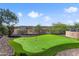 Backyard putting green with flags and desert landscaping behind an iron fence at 13072 W Alyssa Ln, Peoria, AZ 85383