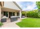 An outdoor covered patio, outdoor kitchen, an artificial grass for easy maintenance in the backyard at 14360 W Windrose Dr, Surprise, AZ 85379