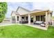 Backyard featuring lush artificial grass, an outdoor kitchen, and a comfortable patio for relaxation and entertainment at 14360 W Windrose Dr, Surprise, AZ 85379