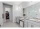 Bathroom featuring dual sinks with granite countertops and entry to closet at 14360 W Windrose Dr, Surprise, AZ 85379