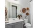 Well-lit bathroom featuring a vanity with dual sinks, woven baskets, and decorative touches at 14360 W Windrose Dr, Surprise, AZ 85379