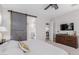 Bedroom featuring barn door access to the bathroom and modern ceiling fan at 14360 W Windrose Dr, Surprise, AZ 85379