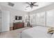 Bright bedroom with plantation shutters and dark wood dresser at 14360 W Windrose Dr, Surprise, AZ 85379
