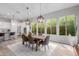 Bright dining room featuring a wooden table, six chairs, stylish lighting and large windows at 14360 W Windrose Dr, Surprise, AZ 85379