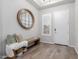Stylish foyer featuring wood flooring, a decorative mirror, a bench, and a white front door at 14360 W Windrose Dr, Surprise, AZ 85379