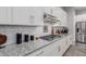 Close-up shot of the kitchen area, highlighting the countertops, subway tile backsplash, and gas range at 14360 W Windrose Dr, Surprise, AZ 85379