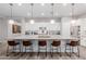 A bright, eat-in kitchen island with granite countertops and seating for five at 14360 W Windrose Dr, Surprise, AZ 85379
