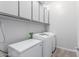 Laundry room including modern washer and dryer appliances and extra cabinet space at 14360 W Windrose Dr, Surprise, AZ 85379