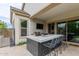 Outdoor kitchen featuring a built in grill, bar and patio seating at 14360 W Windrose Dr, Surprise, AZ 85379