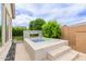 Backyard plunge pool and modern water feature with a tiled surround create a luxurious retreat at 14360 W Windrose Dr, Surprise, AZ 85379