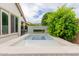Backyard plunge pool with elegant tiled border and a modern water feature against lush greenery at 14360 W Windrose Dr, Surprise, AZ 85379