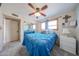 Comfortable bedroom featuring a mirrored closet, ceiling fan, carpet, and bright blue comforter at 14412 N 39Th Ave, Phoenix, AZ 85053